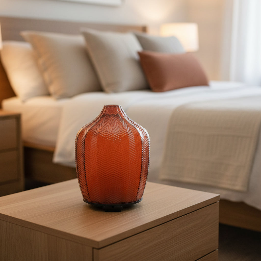 AmberGlow diffuser on a wooden nightstand with a blurred bedroom background